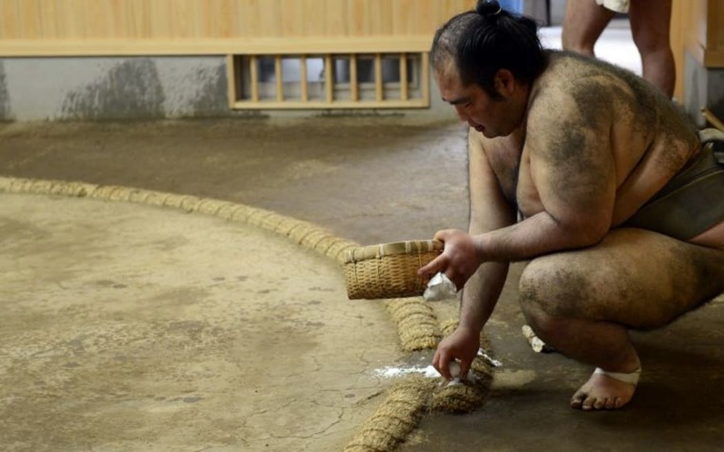 Salt is thrown into the sumo ring before a match to purify it. File photo.