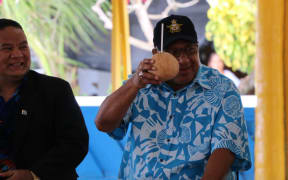 Fiji's prime minister, Frank Bainimarama, raises a coconut on his arrival in Tuvalu for the 2019 Pacific Islands Forum summit.