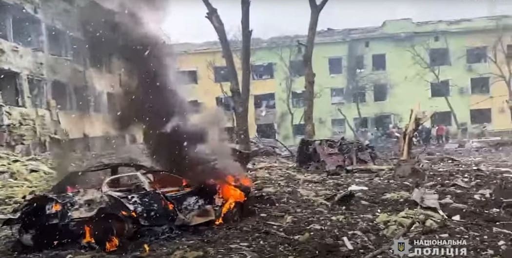This video grab from a handout footage taken and released by the the National Police of Ukraine on March 9, 2022, shows damaged buildings of a children's hospital, destroyed cars and debris on ground following a Russian air strike