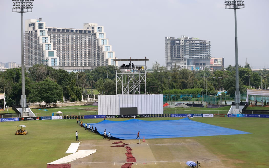 Groundsmen prepare to cover the field during the scheduled one-off Test cricket match between Afghanistan v New Zealand at Greater Noida, India, 2024.