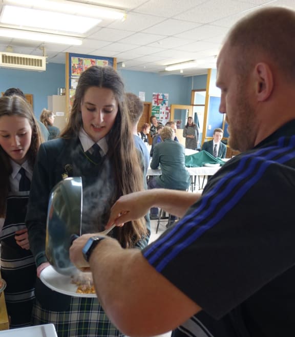 All Black Ben Franks dishes up lunch to a Bayfield High School student.