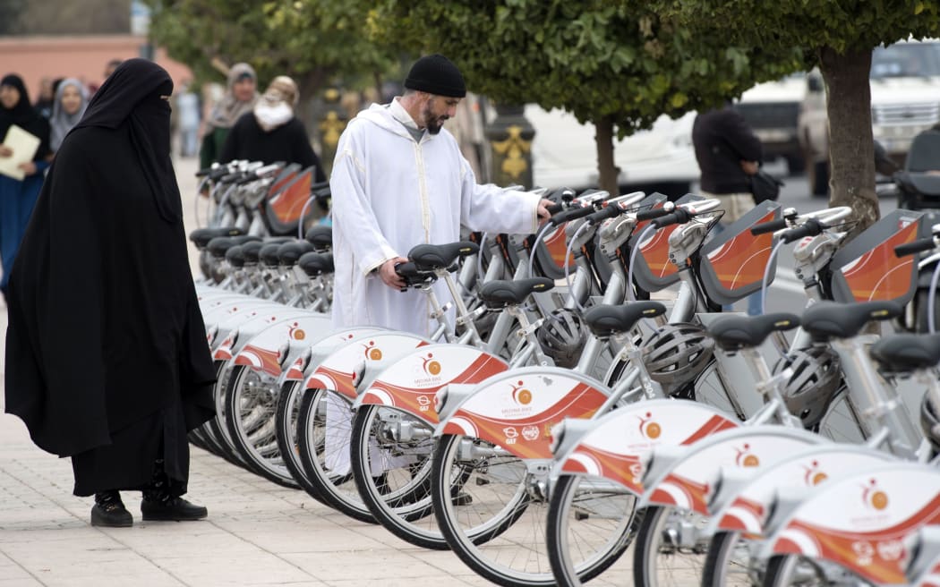 Morrocans inspect the recently installed bicycle sharing system, known as "Medina Bike", in Marrakesh during the COP22 international climate conference.