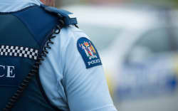 Close up of a police officer at an incident on a residential street. 6 July 2016.