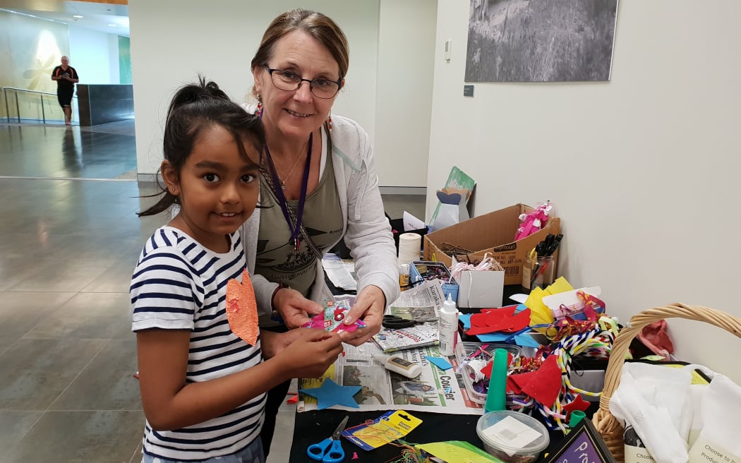 Sue Ollerton, sustainable living skills facilitator at Sustainable Papakura, with 7-year-old Aariya how to make Christmas decorations with rags and other waste that would other wise end up in landfill.