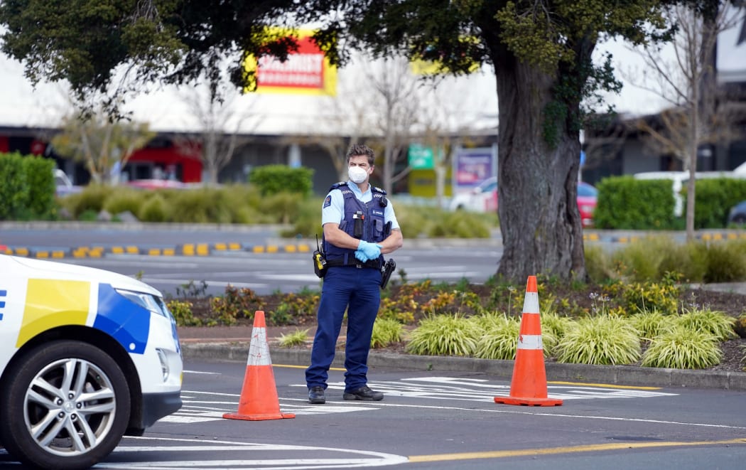 Police keep watch outside the Countdown supermarket at Lynn Mall in Auckland on September 4, 2021, the day after an IS-inspired attacker injured six people in a knife rampage before being shot dead by undercover police.