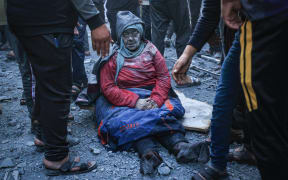 EDITORS NOTE: Graphic content / A woman injured in an Israeli strike sits amid the rubble in Rafah in the southern Gaza Strip on December 3, 2023, amid continuing battles between Israel and the militant group Hamas. Israel carried out deadly bombardments in Gaza on December 3 as international calls mounted for greater protection of civilians and the renewal of an expired truce with Palestinian militant group Hamas. (Photo by SAID KHATIB / AFP)
