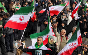 Demonstrators gather with Iranian national flags for a rally in support of the new Supreme Leader at Enghelab Square in central Tehran on March 9, 2026. Iran marked the appointment of Ayatollah Mojtaba Khamenei to replace his father as its supreme leader with a new barrage of missiles against Israel and the Gulf states on Monday, as the Middle East war sent oil prices soaring.