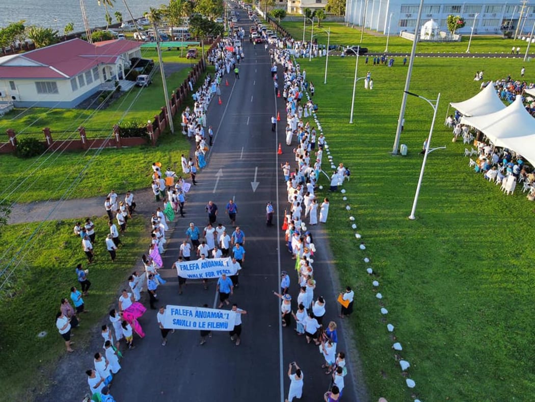 Protesters line both sides of the road to the Apia courthouse,