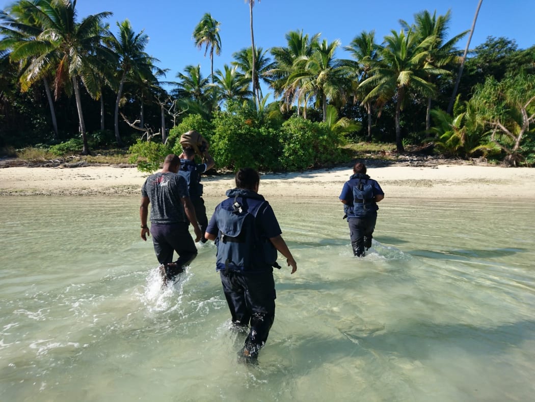 Crew members from Royal New Zealand Navy inshore patrol vessel HMNZS Taupo and personnel from Fiji Revenue and Customs Service wade towards the remote island where over 12 kgs of cocaine were found last week.