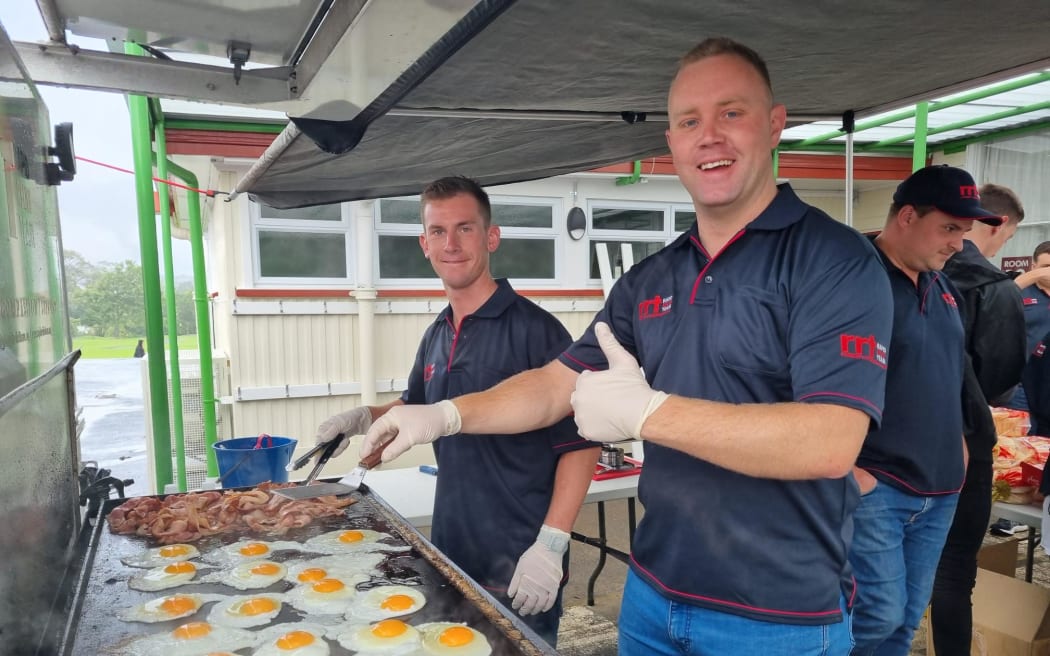 Harland Murray, right, and Brady Forrest cook up some kai at the Kelston evacuation centre