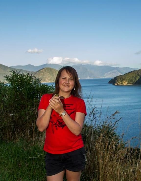 Postdoctoral fellow Zoe Grange, seen here on Maud Island, holding a bellbird.
