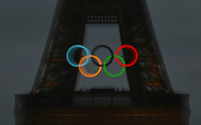 This picture shows the Olympic Rings on the Eiffel Tower during the opening ceremony of the Paris 2024 Olympic Games in Paris on July 26, 2024. (Photo by Fabrice COFFRINI / AFP)