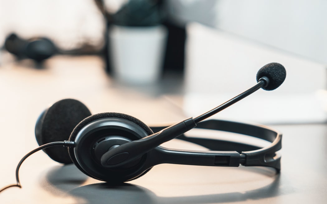 Panorama view of empty call center operator workspace, focused on headset. Representing corporate customer service support and telesales communication technology. Prodigy