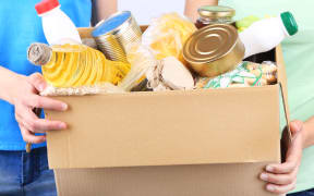 Volunteers with donation box with foodstuffs on grey background - food bank, foodbank