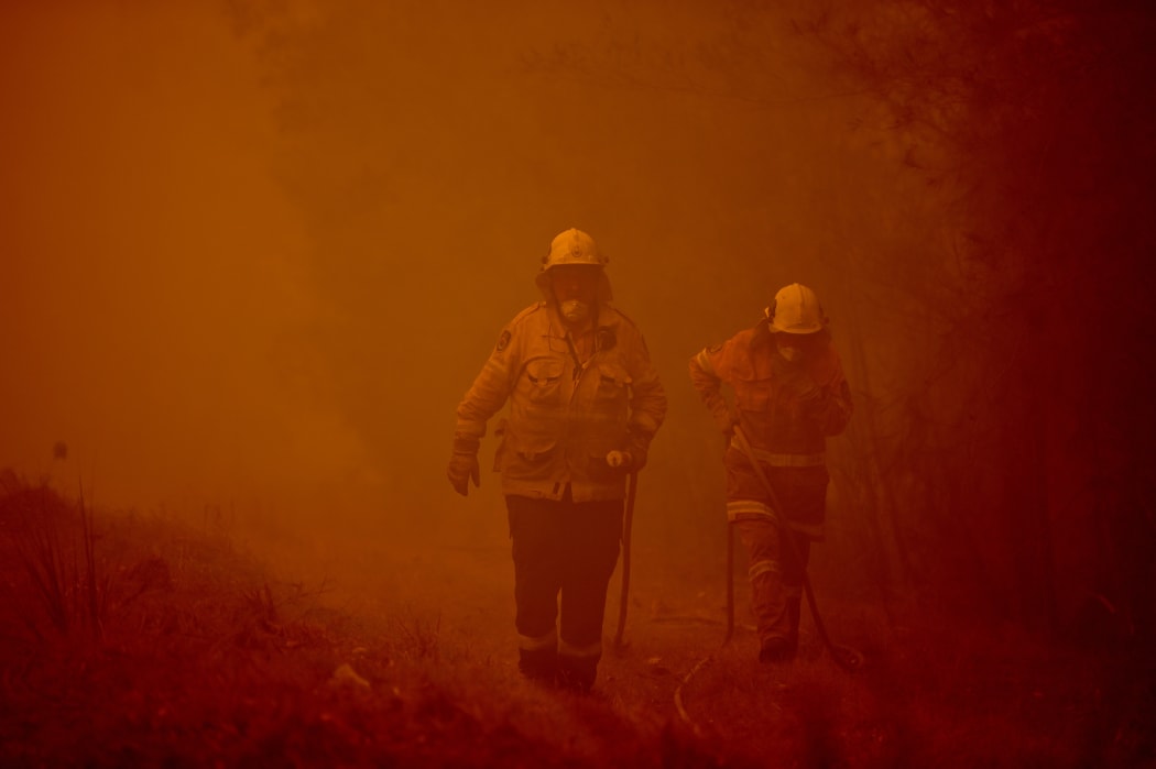Firefighters tackle a bushfire in thick smoke in the town of Moruya, south of Batemans Bay, in New South Wales on January 4, 2020.