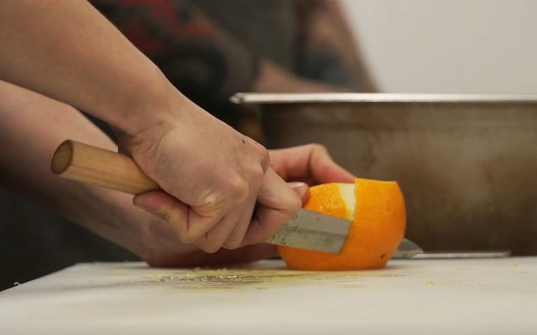 Chef Conor McDonald slicing an orange