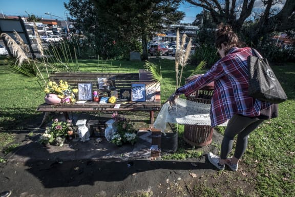 The daughter of homeless man Keith Johnson, who died here on July 1, wraps material around the rubbishbin in St Peter's cemetery in Onehunga where they have made a memorial.