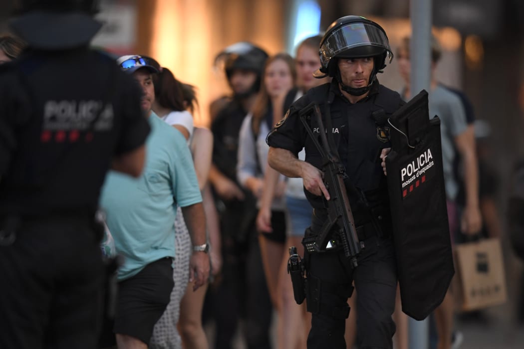 Spanish policemen stand guard in a cordoned off area after a van ploughed into the crowd, killing 13 persons and injuring over 50 on the Rambla in Barcelona on August 17, 2017.