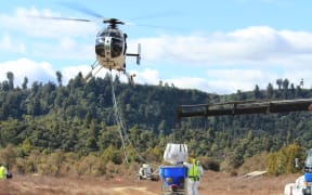 A bait bucket being refilled during an aerial 1080 operation in the Tongariro Conservation Area