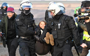 Police officers carry Swedish climate activist Greta Thunberg (centre) out of a group of demonstrators and activists in Erkelenz, western Germany, on January 17, 2023, as demonstrations continue against a coal mine extension in the nearby village of Lützerath. - Already abandoned by its original residents, Luetzerath has become a symbol for resistance against fossil fuels. Energy giant RWE has permission for the expansion of the mine under a compromise agreement that also includes that RWE will stop producing electricity with coal in western Germany by 2030 - eight years earlier than previously planned.
