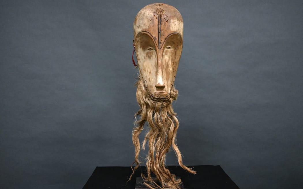 (FILES) This photograph taken on March 24, 2022 shows a "Ngil" mask of the Fang people of Gabon which is estimated at 300,000/400,000 euros and which will be auctioned on March 26, 2022 at the Montpellier auction house. The sale at auction of a rare African sculpted mask for 4.2 million euros, initially bought for 150 euros by a second-hand dealer from an octogenarian couple, was validated on Tuesday by the French courts, and the Gabonese state, third party to the lawsuit, was dismissed. (Photo by Pascal GUYOT / AFP)