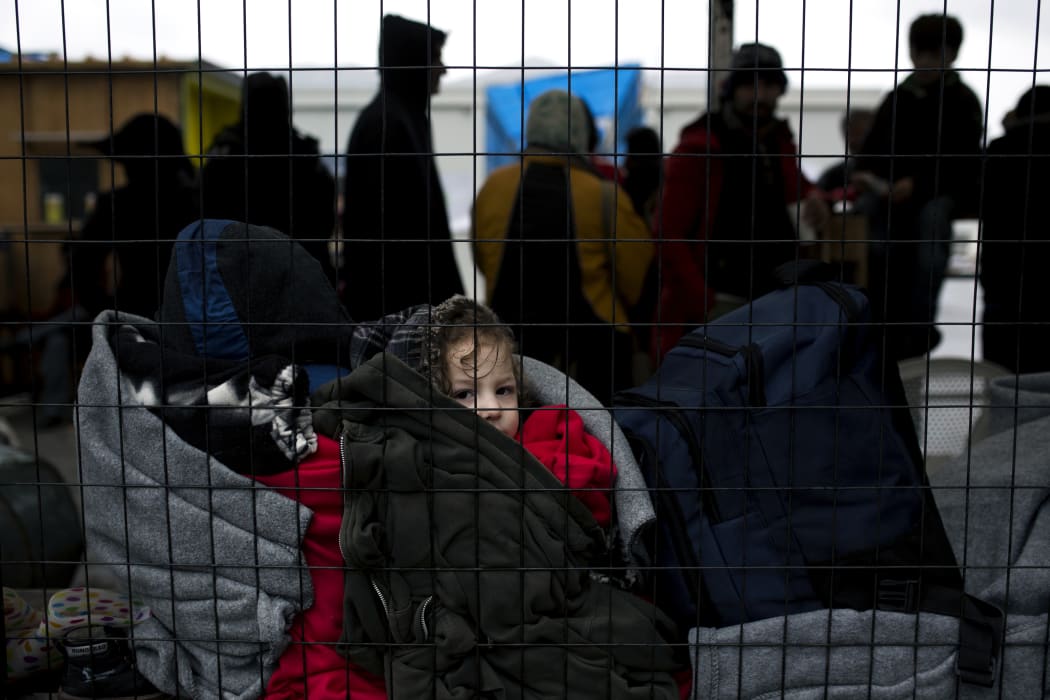 A child waits as people queue inside a migrant registration centre on the Greek island of Samos.