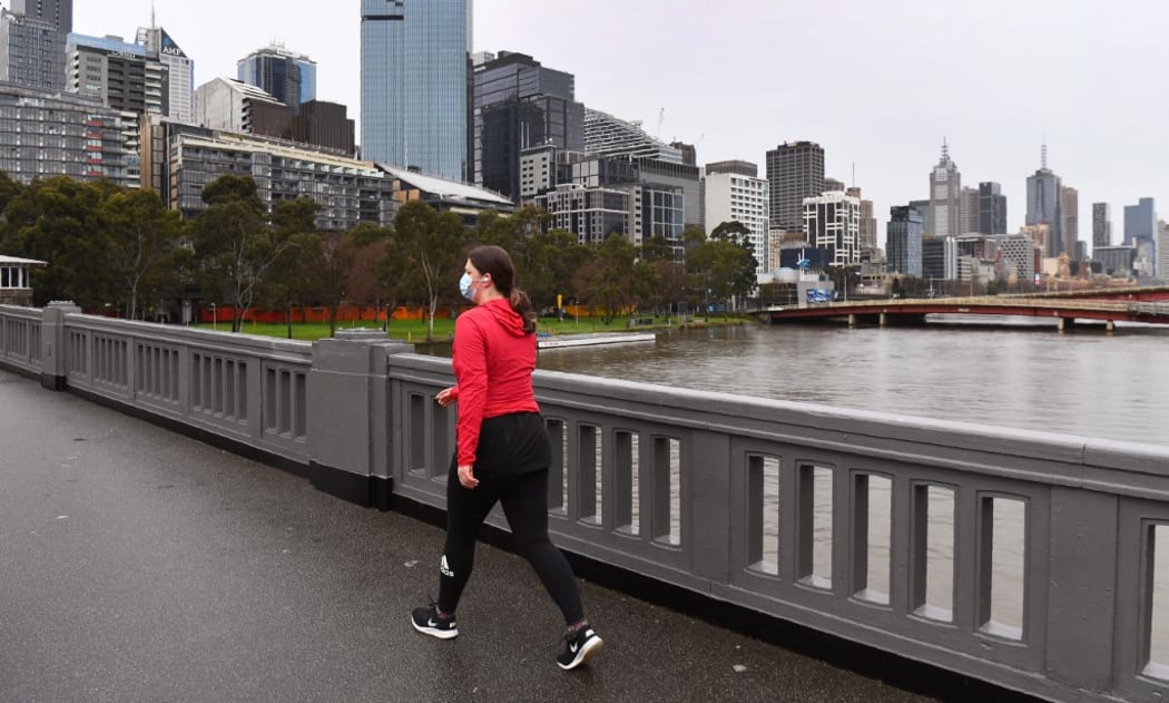 A woman exercises in Melbourne's central business district on August 19, 2020, as the city battles an outbreak of the COVID-19 coronavirus.