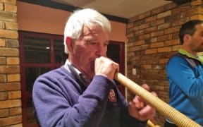 Alan Beck plays the alphorn at the Taranaki Swiss Club.