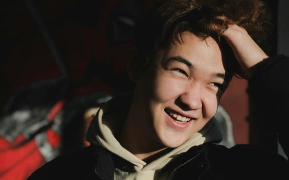 A young men smiles with the sun in his face.