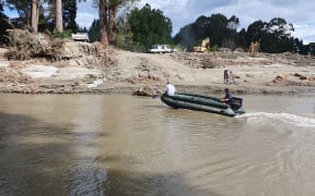 The army green pontoon boat Rissington locals use to ferry essential supplies across the river.