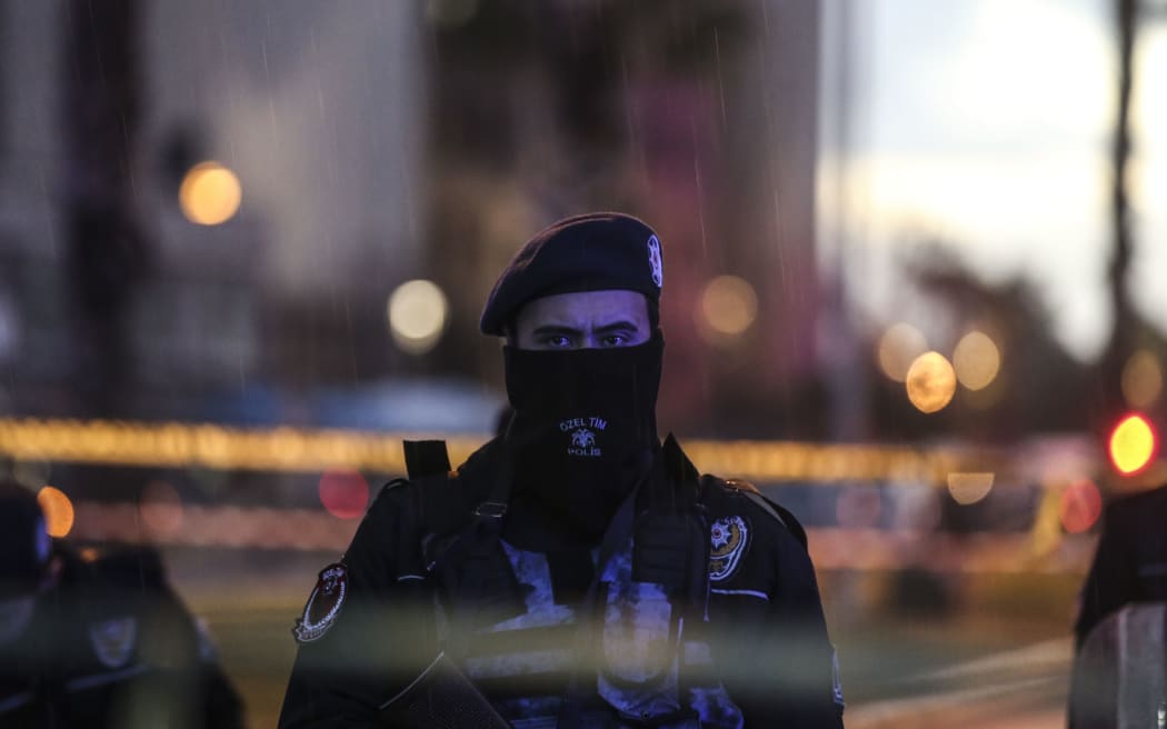 A Turkish police officer stands guard at the site of an explosion in front of the courthouse in Izmi in Turkey.