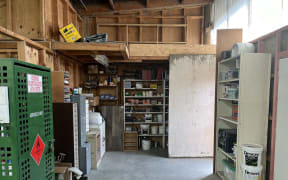 Inside the Gloriavale paint shop are shelves stacked with tinned paint, brushes, filing cabinets and drawers and a locked cabinet of aerosol paint.