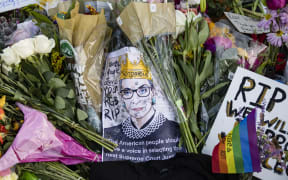 Mourners place flowers, messages, and mementos at a makeshift memorial in honor of Supreme Court Justice Ruth Bader Ginsburg in front of the US Supreme Court
