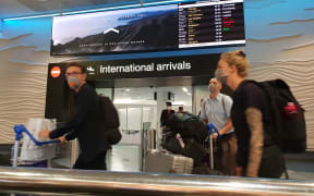 Travellers with face masks at Auckland Airport international arrivals during the Covid-19 coronavirus outbreak on 20/3/2020.