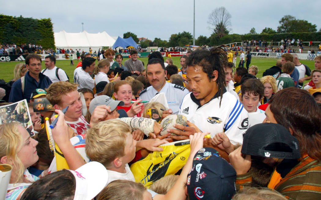 Tana Umaga gets mobbed by fans after the Hurricanes 28-27 win over the Highlanders in 2004.