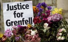 Flowers and messages left by well-wishers in tribute to the victims of the June 14 Grenfell Tower block are pictured near the scene of the fire in North Kensington, west London on June 22, 2017.