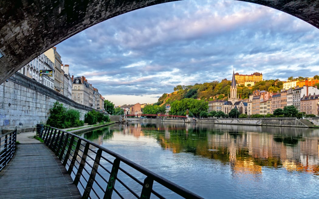 Pedestrian Saint George's footbridge and the Saint Georges church in a beautiful morning, Lyon, France