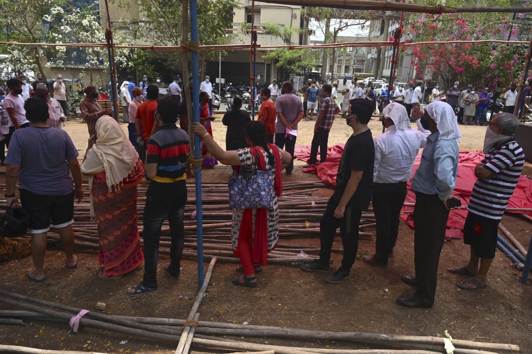 People stand in queues to get their Covid-19 vaccine at a vaccination centre in Mumbai, 26  April 2021.