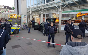 Police officers guarding a car in front of the building in Heidelberg where the man drove into pedestrians.