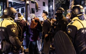 Participants in a pro-Palestinian protest are evacuated by bus under police surveillance at the campus of the University of Amsterdam (UvA) on Roeterseiland.