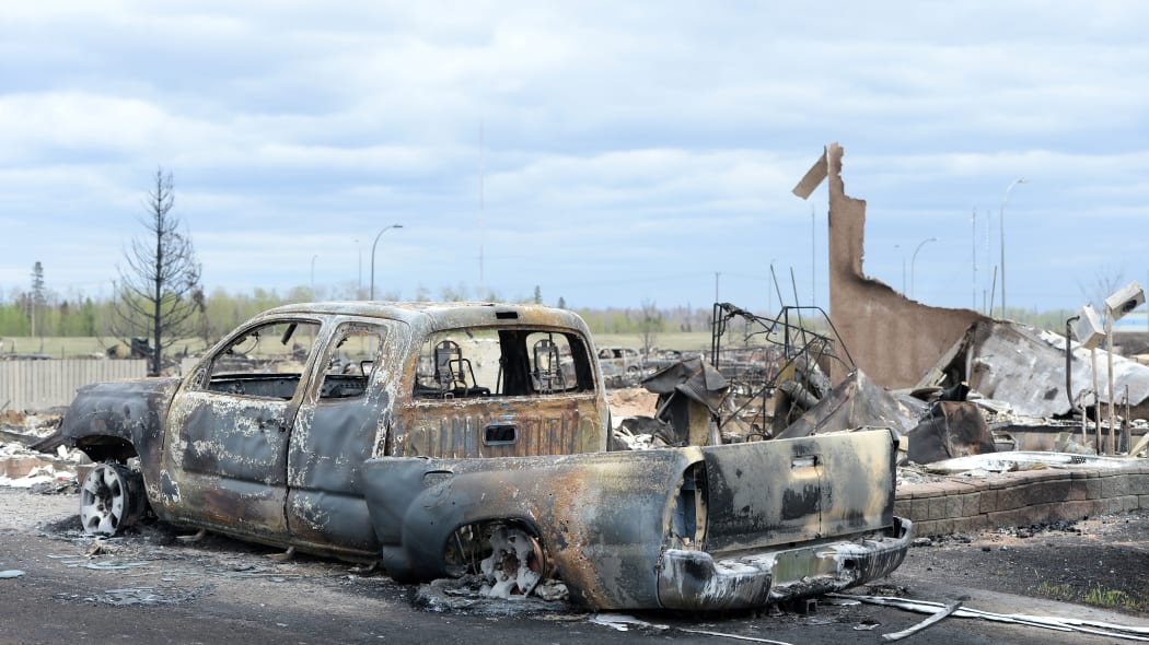 A burned out truck and the remains of a house in the Beacon Hill neighbourhood of Fort McMurray.