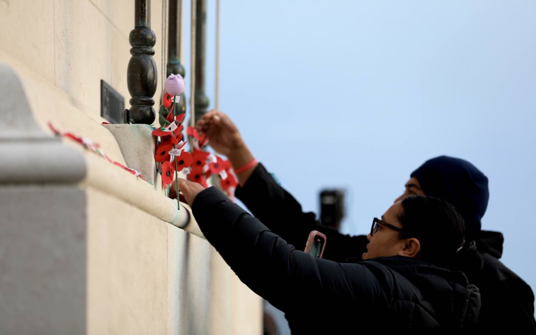 People laying poppies at Auckland War Memorial Museum on Anzac Day 25 April 2025.