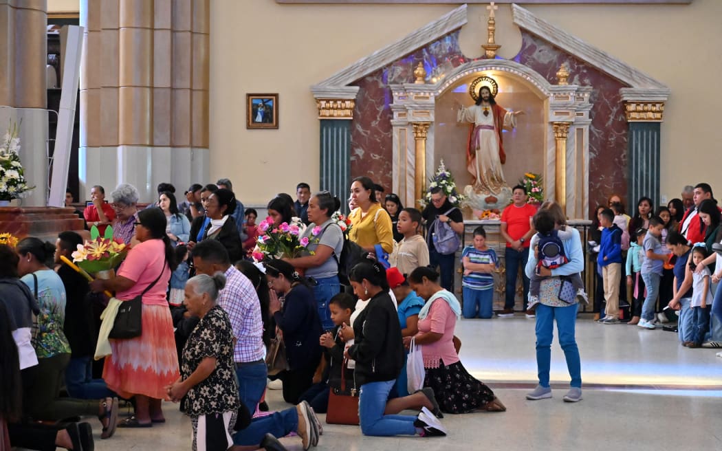 Catholic parishioners pray for the health of Pope Francis at the Basilica of Suyapa in Tegucigalpa on 16 February, 2025. Pope Francis followed Sunday mass and his traditional Angelus weekly prayer on television in a Rome hospital where the 88-year-old pontiff is being treated for bronchitis. (Photo by Orlando SIERRA / AFP)