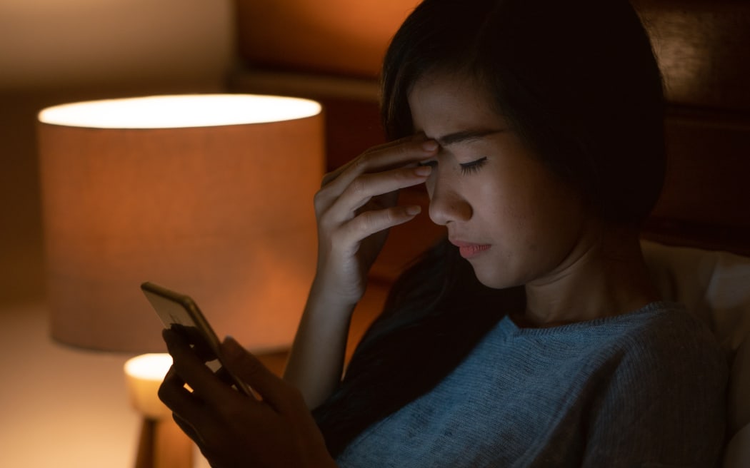unhappy girl feeling sad reading bad news in smartphone on bed