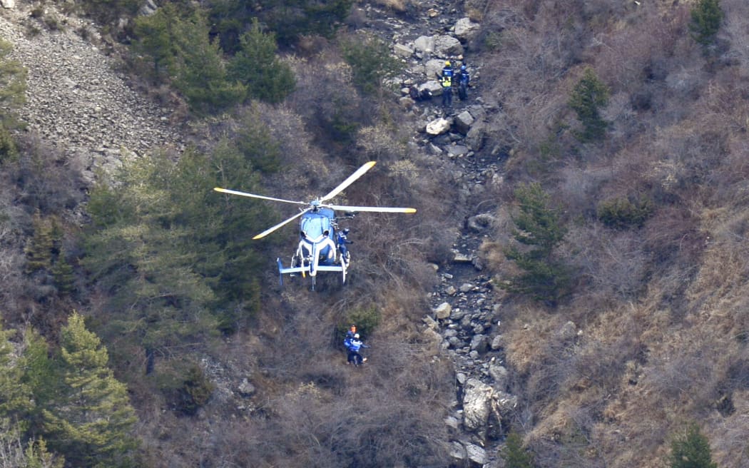 A helicopter lowers search and rescue personnel close to the crash site of the Germanwings Airbus A320 in the French Alps.