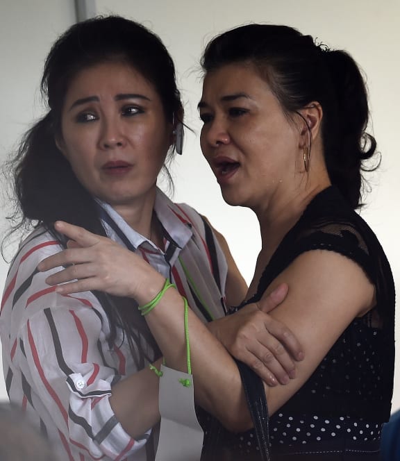 Relatives of passengers on board the AirAsia flight react to the news that debris has been found.