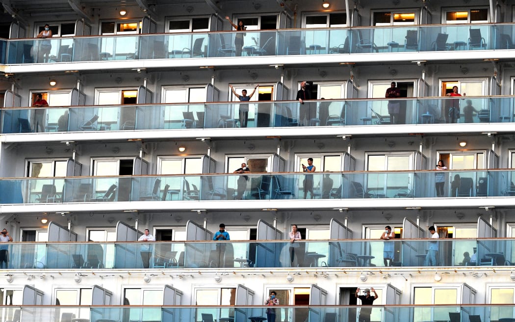 People wave as the cruise ship Ruby Princess departs from Port Kembla, some 80 kilometres south of Sydney, on 23 April, 2020.