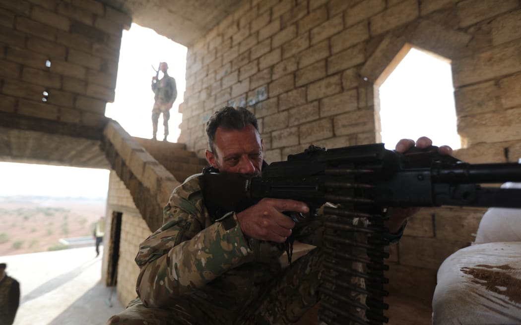A Turkey-backed Syrian fighter sits behind a machine gun at a fortified position in Jarablus close to the border with Turkey in the rebel-held north of Syria's Aleppo province.