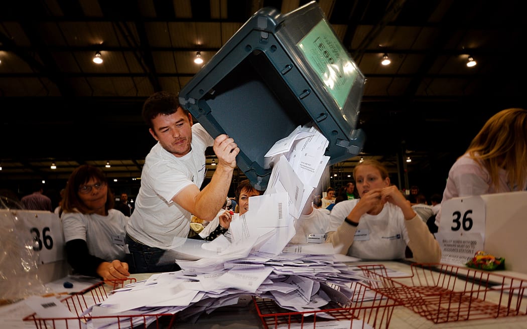 A worker tips out a ballot box from the Scottish referendum.
