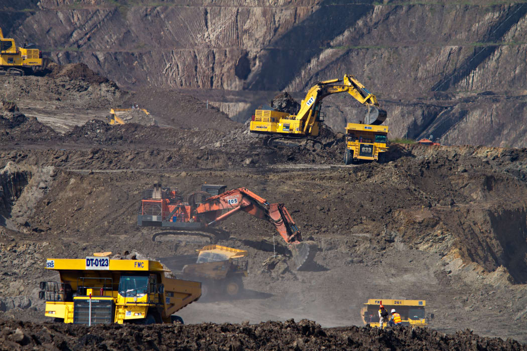 Excavators and trucks at a coal mine in South Kalimantan, Indonesia.